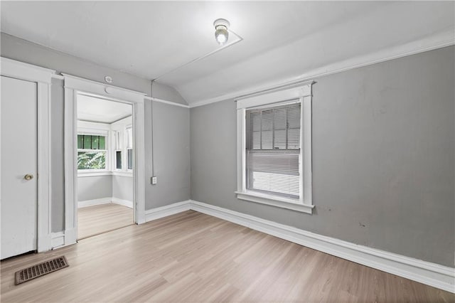3544 College Ave, Kansas City, MO 64128 - unfurnished room with vaulted ceiling and wood finished floors