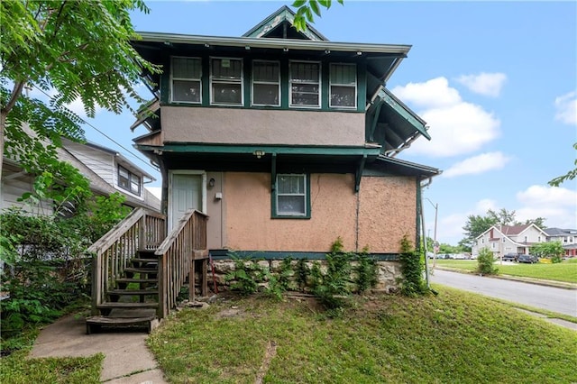3544 College Ave, Kansas City, MO 64128 - view of front of property featuring stucco siding and a front yard
