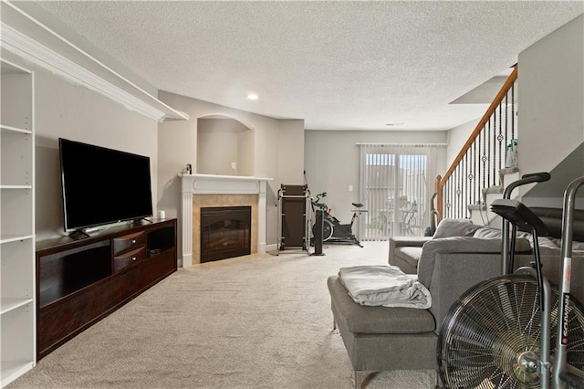 820 Peach Tree Ln, Blue Springs, MO 64064 - living room featuring carpet floors, a tile fireplace, a textured ceiling, recessed lighting, and stairs