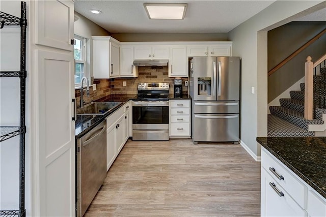 3524 NE Austin Dr, Lees Summit, MO 64064 - kitchen with stainless steel appliances, white cabinets, tasteful backsplash, light wood-style floors, and under cabinet range hood