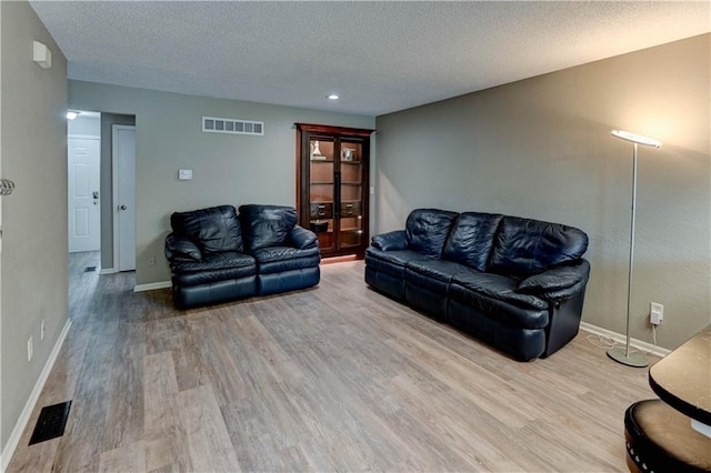 3524 NE Austin Dr, Lees Summit, MO 64064 - living area featuring wood finished floors, a textured ceiling, and recessed lighting