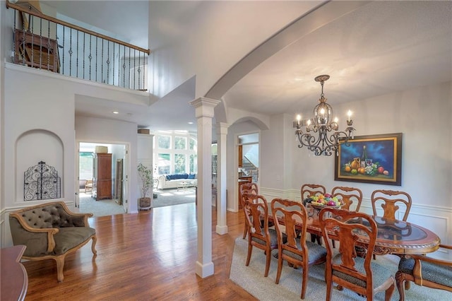 3013 S Granite Ave, Blue Springs, MO 64015 - dining room featuring arched walkways, a chandelier, ornate columns, and wood finished floors