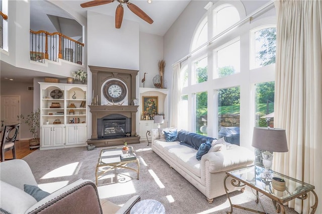 3013 S Granite Ave, Blue Springs, MO 64015 - living room with a high ceiling, a ceiling fan, and a glass covered fireplace