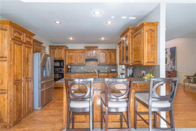 3013 S Granite Ave, Blue Springs, MO 64015 - kitchen with black appliances, brown cabinets, under cabinet range hood, a peninsula, and recessed lighting