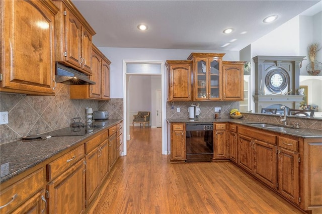 3013 S Granite Ave, Blue Springs, MO 64015 - kitchen with black appliances, under cabinet range hood, wood finished floors, brown cabinetry, and glass insert cabinets