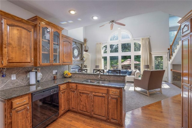 3013 S Granite Ave, Blue Springs, MO 64015 - kitchen with dishwasher, ceiling fan, brown cabinetry, light wood finished floors, and a high ceiling