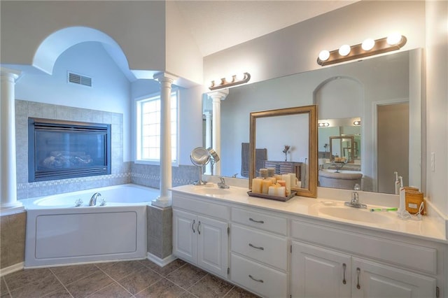 3013 S Granite Ave, Blue Springs, MO 64015 - bathroom featuring decorative columns, lofted ceiling, double vanity, a bath, and tile patterned flooring