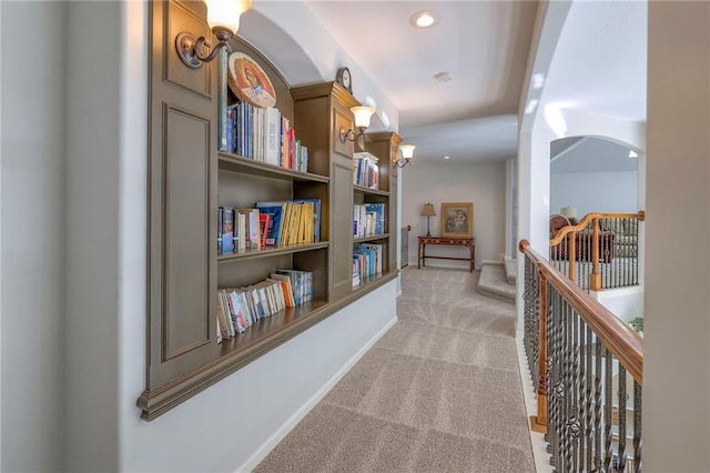 3013 S Granite Ave, Blue Springs, MO 64015 - corridor featuring light colored carpet, an upstairs landing, built in shelves, and arched walkways
