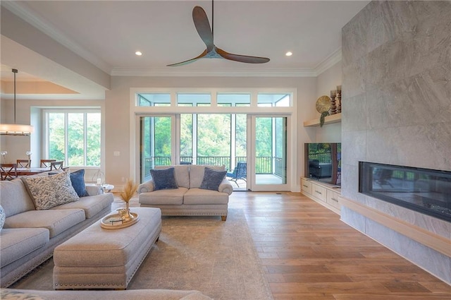 7736 N Donnelly Ave, Kansas City, MO 64158 - living area with crown molding, a ceiling fan, light wood-style floors, a tile fireplace, and recessed lighting