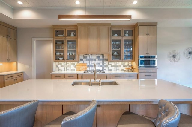 7736 N Donnelly Ave, Kansas City, MO 64158 - kitchen with light countertops, a kitchen breakfast bar, tasteful backsplash, stainless steel appliances, and recessed lighting