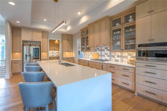 7736 N Donnelly Ave, Kansas City, MO 64158 - kitchen with stainless steel appliances, light brown cabinets, a raised ceiling, light wood finished floors, and recessed lighting