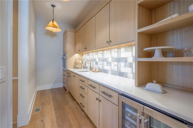 7736 N Donnelly Ave, Kansas City, MO 64158 - kitchen featuring open shelves, stainless steel oven, light countertops, and beverage cooler