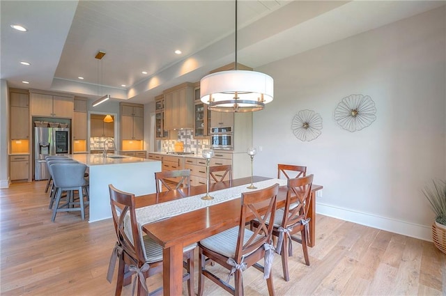 7736 N Donnelly Ave, Kansas City, MO 64158 - dining area featuring light wood-style floors, a raised ceiling, and recessed lighting