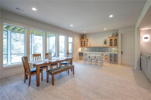 7736 N Donnelly Ave, Kansas City, MO 64158 - dining space with beverage cooler, light carpet, a dry bar, and recessed lighting
