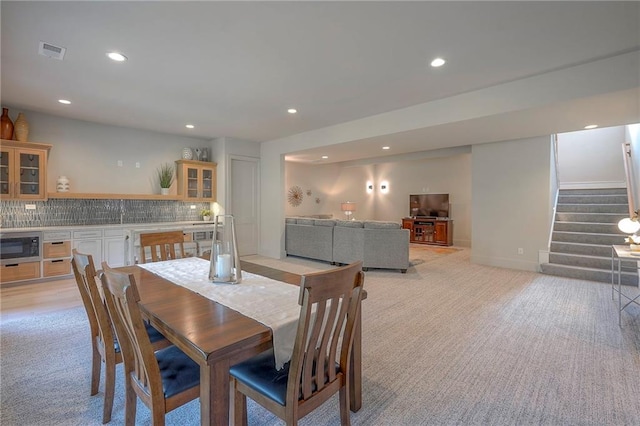 7736 N Donnelly Ave, Kansas City, MO 64158 - dining area featuring light colored carpet, recessed lighting, stairs, and bar