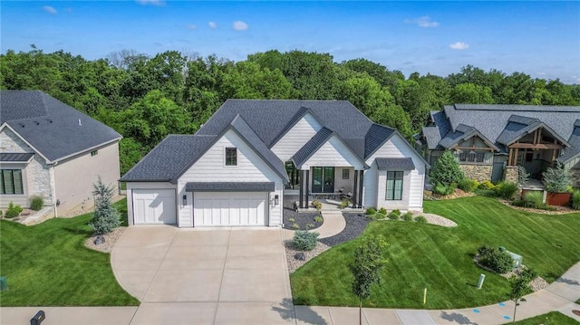 7736 N Donnelly Ave, Kansas City, MO 64158 - view of front of home with driveway, an attached garage, and a front lawn