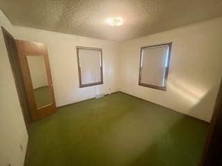 3716 W 48th St, Roeland Park, KS 66205 - unfurnished bedroom featuring a textured ceiling and dark carpet