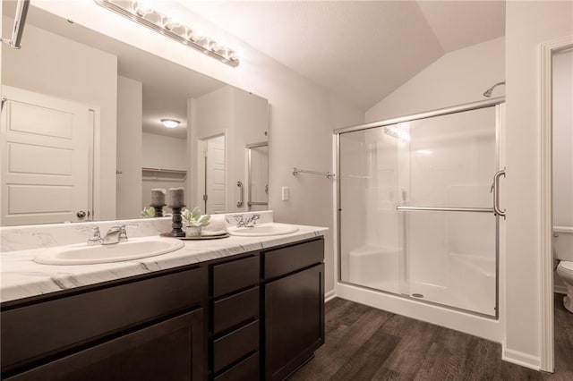 7908 SE 6th Ter, Blue Springs, MO 64014 - bathroom featuring wood finished floors, double vanity, a stall shower, vaulted ceiling, and a closet