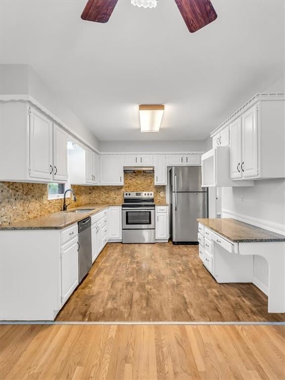 3717 S Hocker St, Independence, MO 64055 - kitchen with appliances with stainless steel finishes, ceiling fan, white cabinets, backsplash, and light wood-type flooring