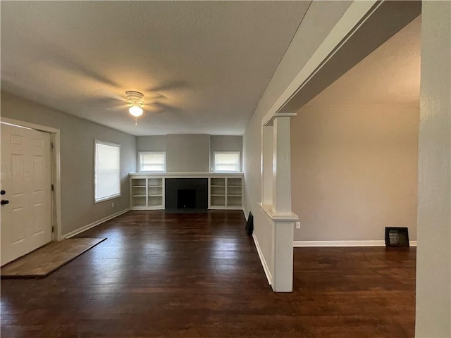 4916 Wabash Ave, Kansas City, MO 64130 - unfurnished living room featuring a ceiling fan, wood finished floors, a fireplace, and a textured ceiling