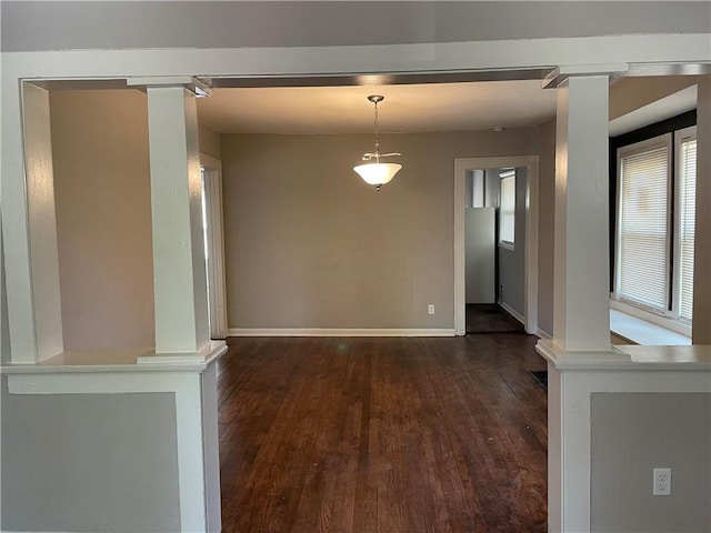 4916 Wabash Ave, Kansas City, MO 64130 - unfurnished dining area with ornate columns and dark wood-style floors