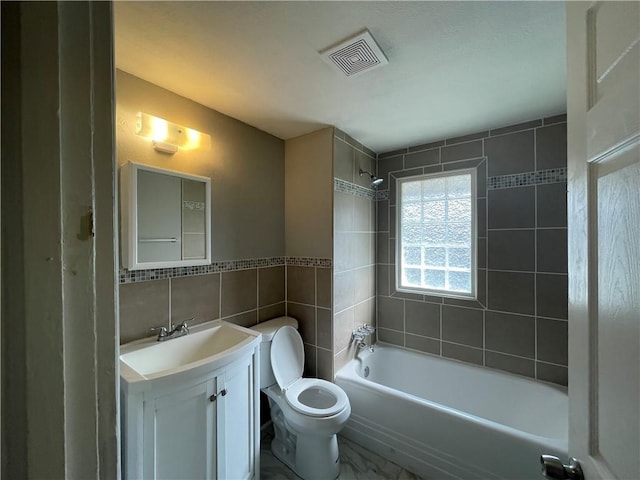 4916 Wabash Ave, Kansas City, MO 64130 - full bathroom featuring tile walls, vanity, and  shower combination
