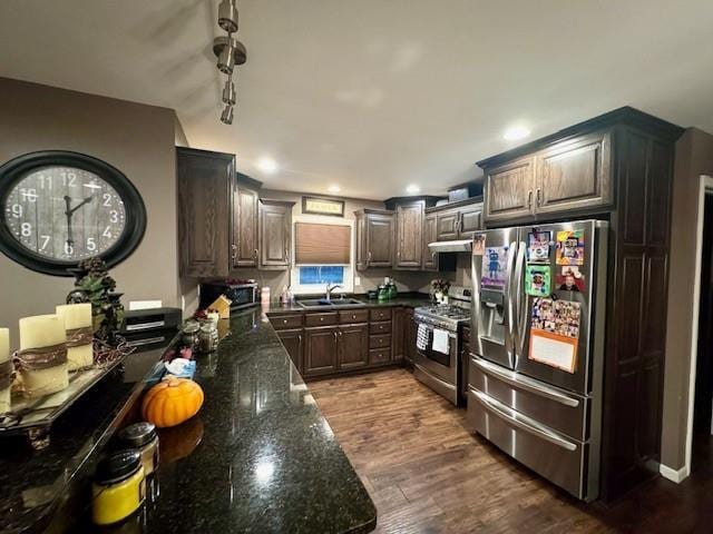 1878 US Highway 54, Iola, KS 66749 - kitchen with appliances with stainless steel finishes, dark wood-style floors, dark stone counters, range hood, and recessed lighting