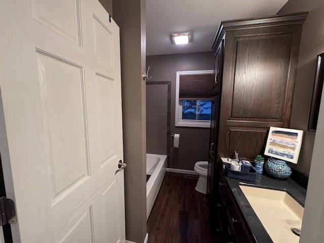 1878 US Highway 54, Iola, KS 66749 - bathroom featuring vanity, wood finished floors, and bathtub / shower combination