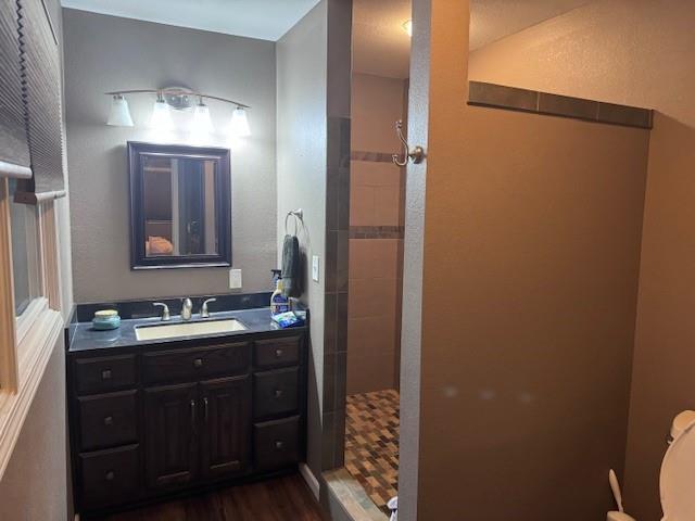 1878 US Highway 54, Iola, KS 66749 - full bath featuring a tile shower, vanity, and wood finished floors