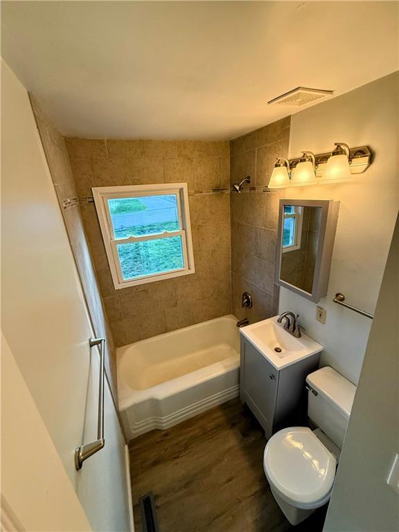 2321 Englewood Ct, Independence, MO 64052 - bathroom with wood finished floors, vanity, and bathtub / shower combination