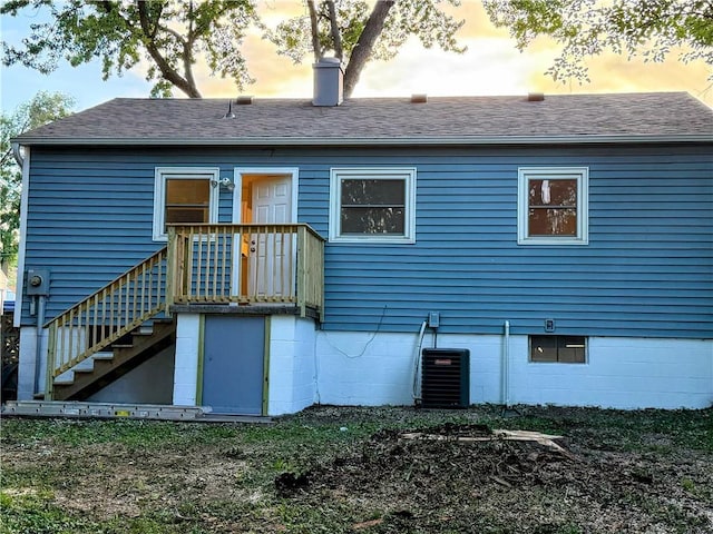 2321 Englewood Ct, Independence, MO 64052 - back of house at dusk with a chimney and roof with shingles