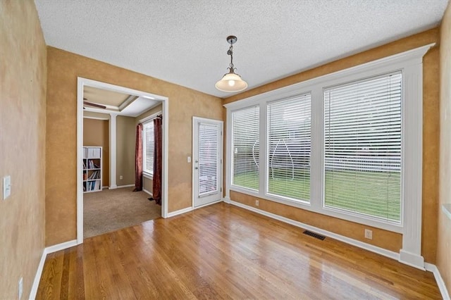 6715 W 148th Ter, Overland Park, KS 66223 - unfurnished dining area featuring wood finished floors and a textured ceiling