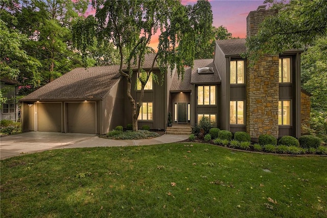 11909 Goddard St, Overland Park, KS 66213 - view of front of house featuring a garage, concrete driveway, a chimney, a shingled roof, and a lawn