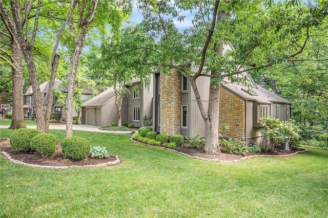 11909 Goddard St, Overland Park, KS 66213 - view of home's exterior featuring stone siding and a lawn
