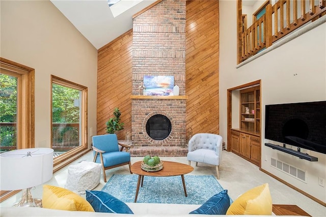11909 Goddard St, Overland Park, KS 66213 - living area featuring high vaulted ceiling, wooden walls, a skylight, a fireplace, and light colored carpet