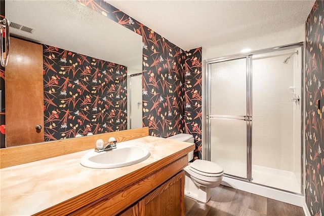 11909 Goddard St, Overland Park, KS 66213 - full bath with wallpapered walls, wood finished floors, a stall shower, vanity, and a textured ceiling