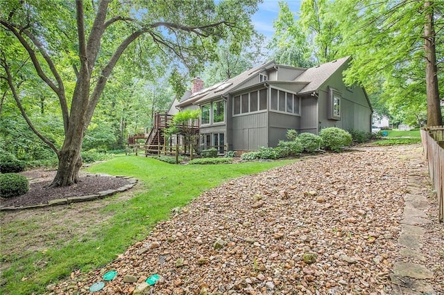 11909 Goddard St, Overland Park, KS 66213 - view of side of property featuring a chimney, a wooden deck, and a sunroom