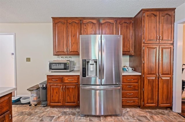 1621 Vilas St, Leavenworth, KS 66048 - kitchen featuring appliances with stainless steel finishes, light countertops, a textured ceiling, and brown cabinets