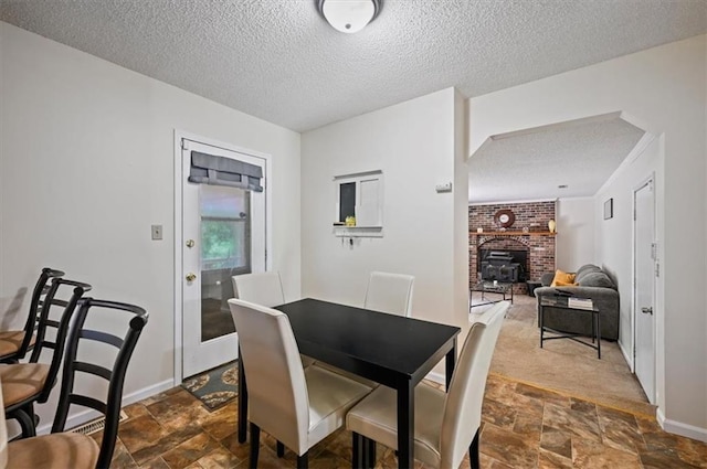 1621 Vilas St, Leavenworth, KS 66048 - dining area featuring a textured ceiling, stone finish floors, and a wood stove
