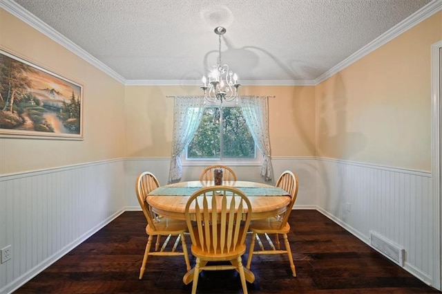 1621 Vilas St, Leavenworth, KS 66048 - dining room with wainscoting, wood-type flooring, a chandelier, a textured ceiling, and crown molding