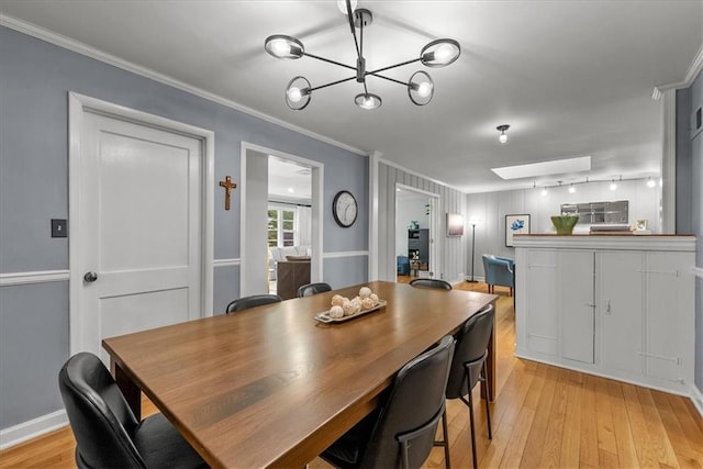 2819 W 89th St, Leawood, KS 66206 - dining space with ornamental molding, a chandelier, light wood finished floors, and a skylight