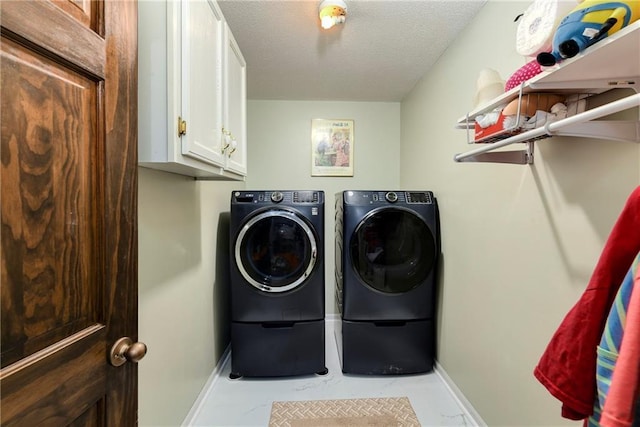 407 Maple Ct, Lansing, KS 66043 - laundry room featuring separate washer and dryer, a textured ceiling, light marble finish floors, and cabinet space