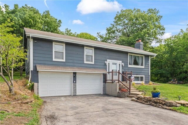 10708 E 301st St, Drexel, MO 64742 - bi-level home with a chimney, driveway, an attached garage, and a front yard