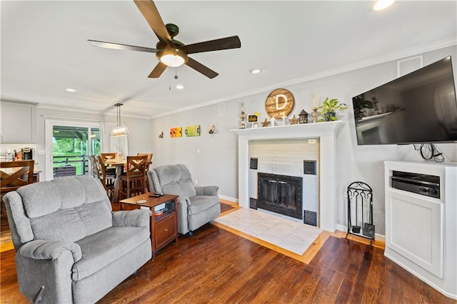 10708 E 301st St, Drexel, MO 64742 - living room with dark wood finished floors, ceiling fan, recessed lighting, a tile fireplace, and ornamental molding