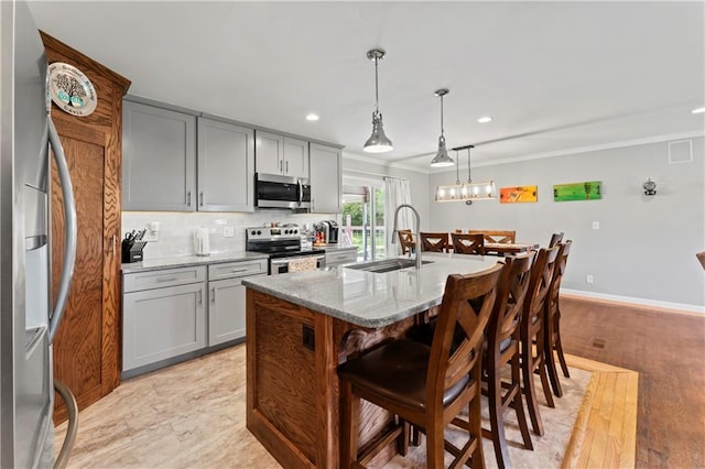 10708 E 301st St, Drexel, MO 64742 - kitchen with appliances with stainless steel finishes, gray cabinets, recessed lighting, light stone countertops, and a breakfast bar