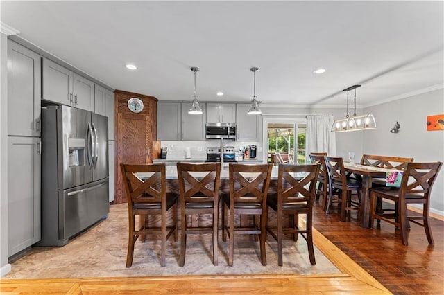 10708 E 301st St, Drexel, MO 64742 - kitchen featuring stainless steel appliances, ornamental molding, gray cabinetry, a breakfast bar, and recessed lighting