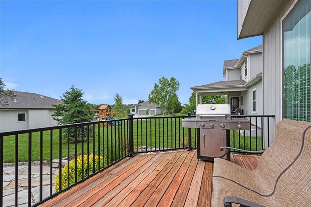 24957 W 98th St, Lenexa, KS 66227 - wooden deck featuring area for grilling, a playground, a yard, and a residential view