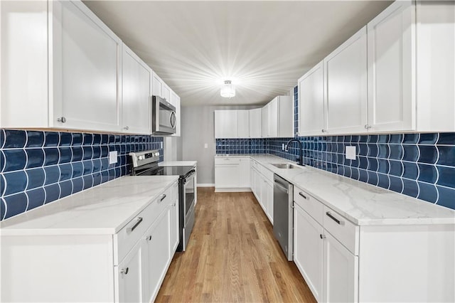 4301 W 74th St, Prairie Village, KS 66208 - kitchen featuring stainless steel appliances, decorative backsplash, light wood-style flooring, and light stone countertops