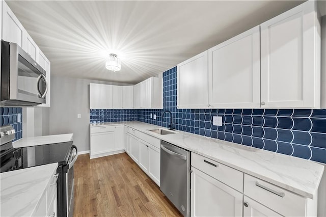 4301 W 74th St, Prairie Village, KS 66208 - kitchen featuring stainless steel appliances, decorative backsplash, light wood-style floors, and white cabinetry