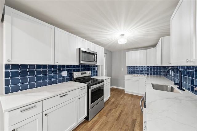 4301 W 74th St, Prairie Village, KS 66208 - kitchen featuring appliances with stainless steel finishes, decorative backsplash, white cabinets, and light stone countertops